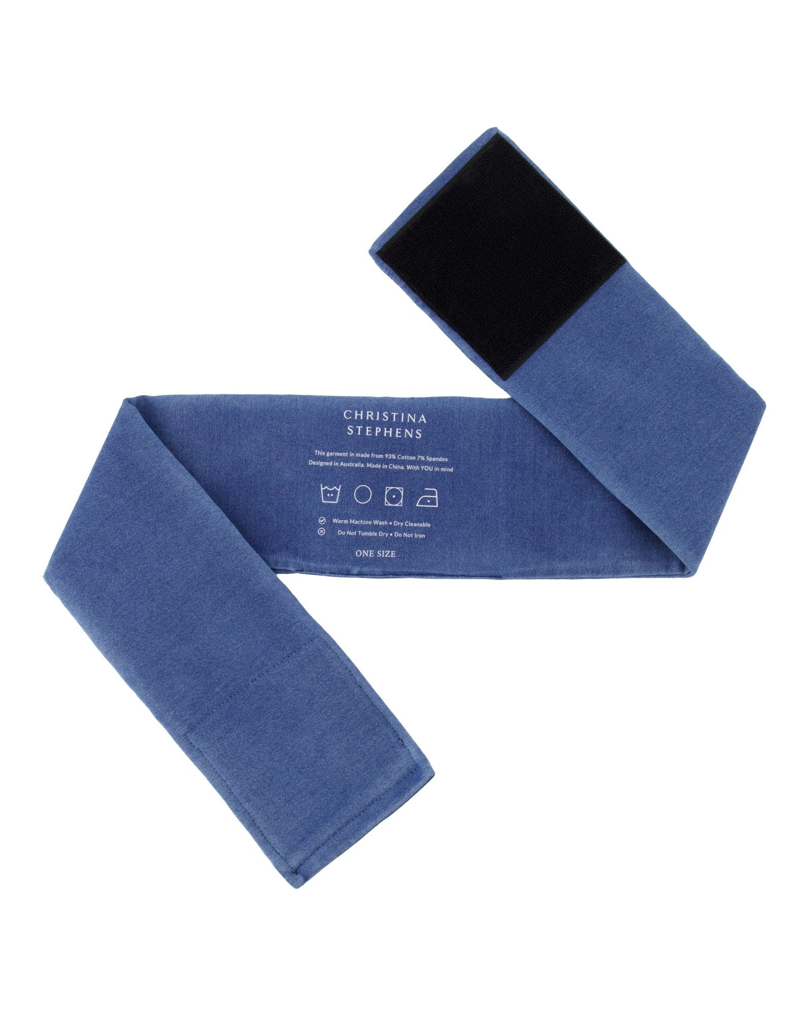 Wheelchair Leg Strap in denim blue with black velcro fastener, featuring care instructions printed on soft fabric. Product shown flat and unfolded displaying full length and width of the adjustable support strap.