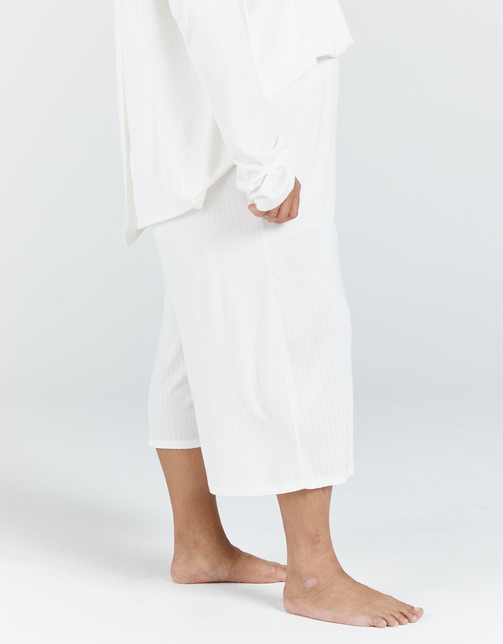 Essensual PJ Set - Pure white cotton pajama set with cropped pants and loose-fitting design, showcasing comfortable sleepwear with a minimalist aesthetic and relaxed silhouette against a light background