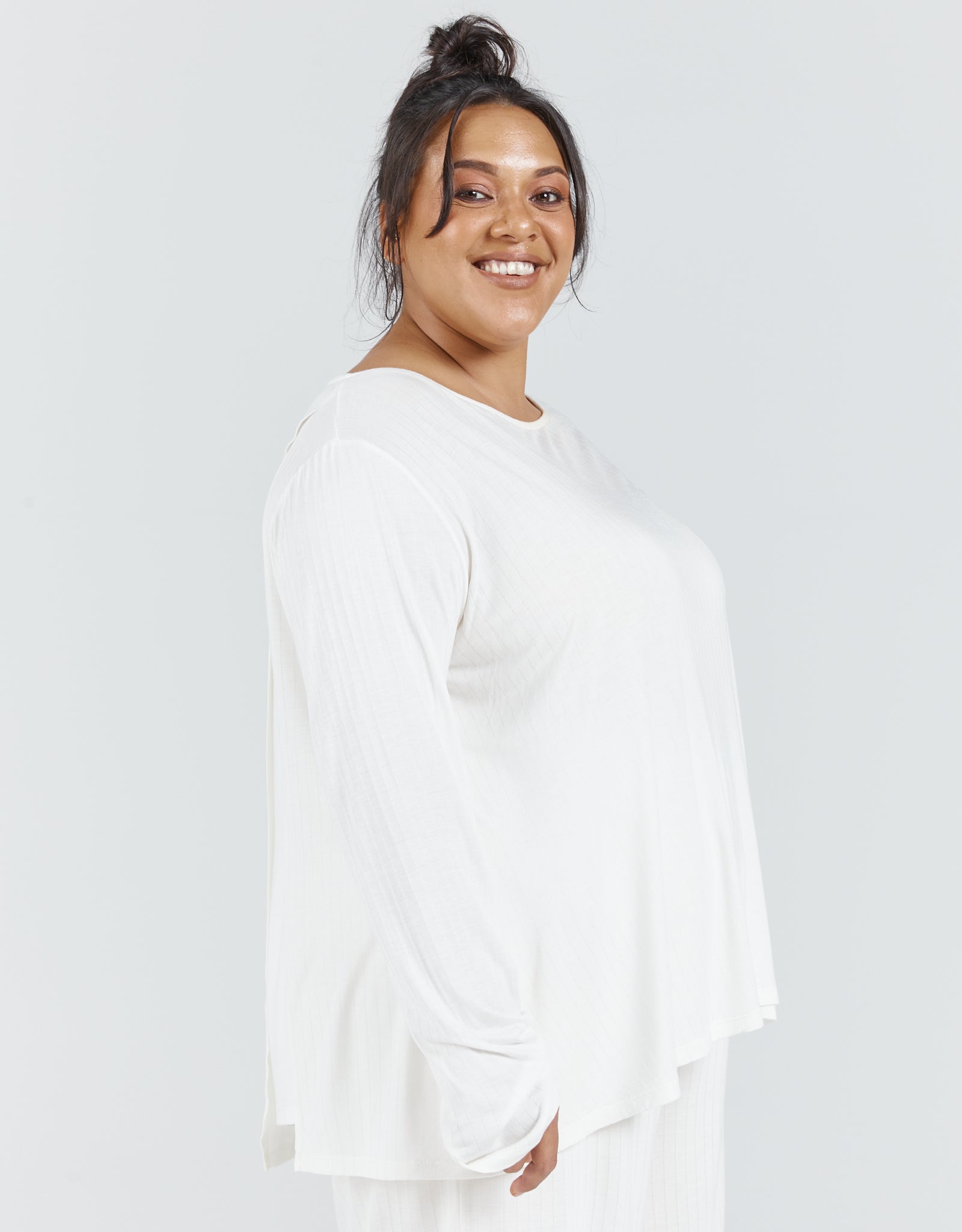 Essensual PJ Set featuring a flowing white long-sleeve top with a relaxed fit and round neckline, shown against a light gray background. The comfortable sleepwear piece exemplifies casual elegance and adaptive fashion design.