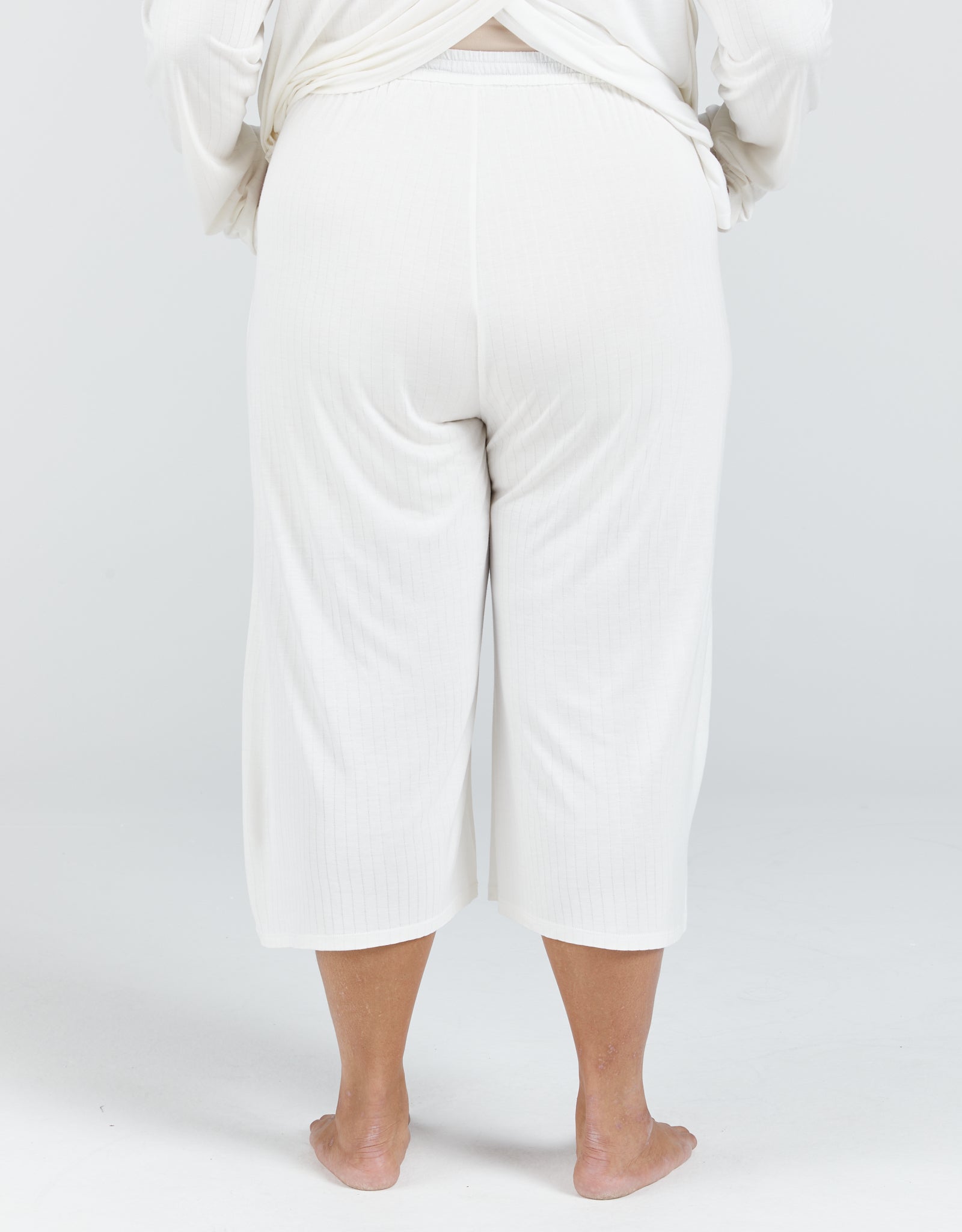 Essensual PJ Set in crisp white, featuring comfortable cropped wide-leg pants with elastic waistband, shown from back view against light background, perfect for easy nighttime wear and unrestricted movement during sleep.