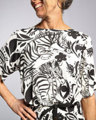 Lilli Leaf Back T-Shirt featuring a striking black and white abstract floral and zebra print pattern on sensory-friendly bamboo fabric, showcasing loose-fit elbow-length sleeves and a relaxed neckline. Side view displays the artistic print detail against a light gray background.