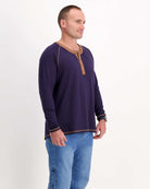 Sir Lord Raglan T-Shirt shown in navy blue with contrasting brown henley collar and trim, styled with blue jeans against white background, displaying classic A-line silhouette and long sleeve design