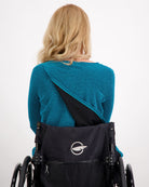 Karni Glitter Top shown from back view, featuring innovative leaf-back design in vibrant teal metallic fabric, demonstrating adaptive opening against white background. Wheelchair-friendly evening wear showcasing stylish accessibility features.