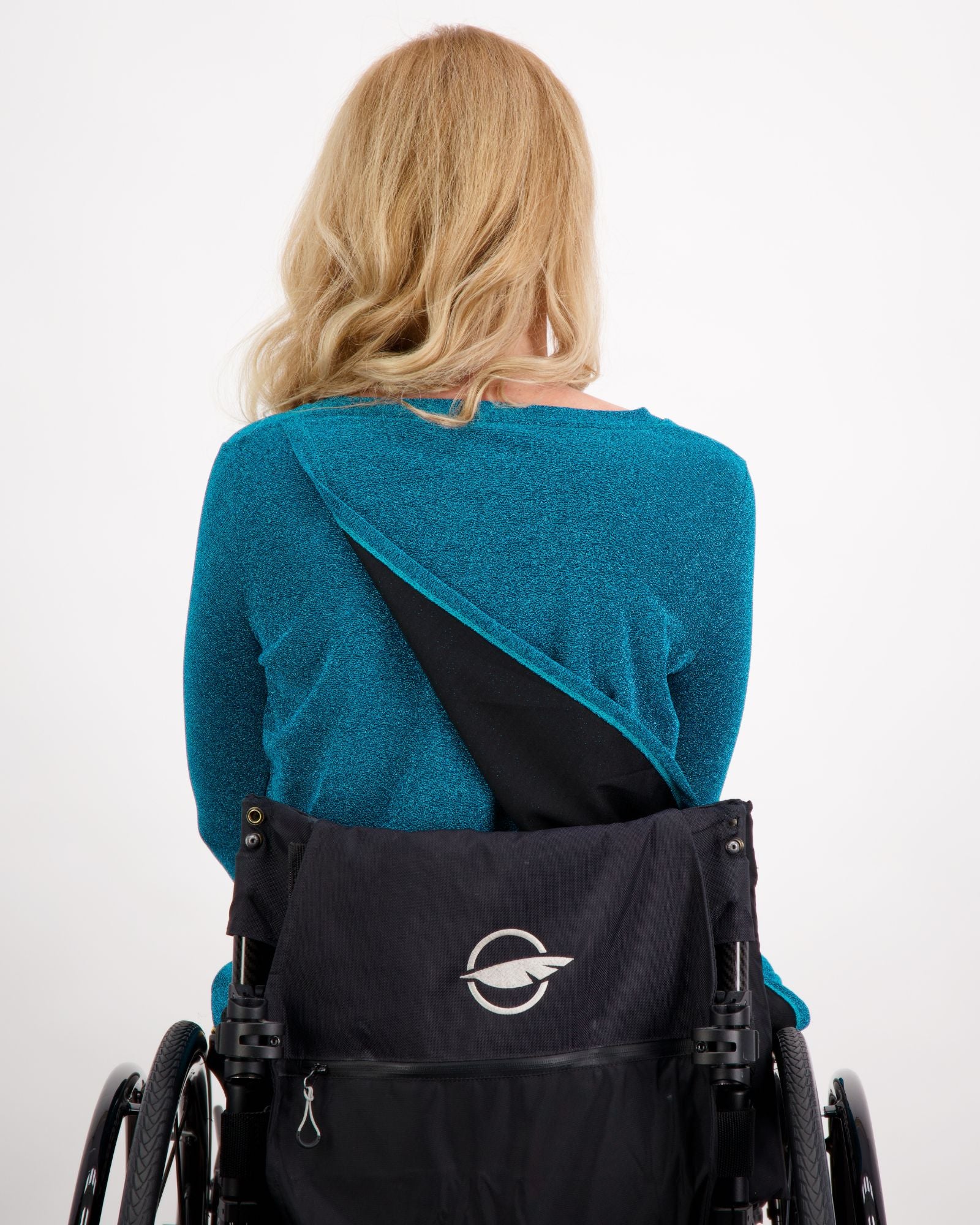 Karni Glitter Top shown from back view, featuring innovative leaf-back design in vibrant teal metallic fabric, demonstrating adaptive opening against white background. Wheelchair-friendly evening wear showcasing stylish accessibility features.