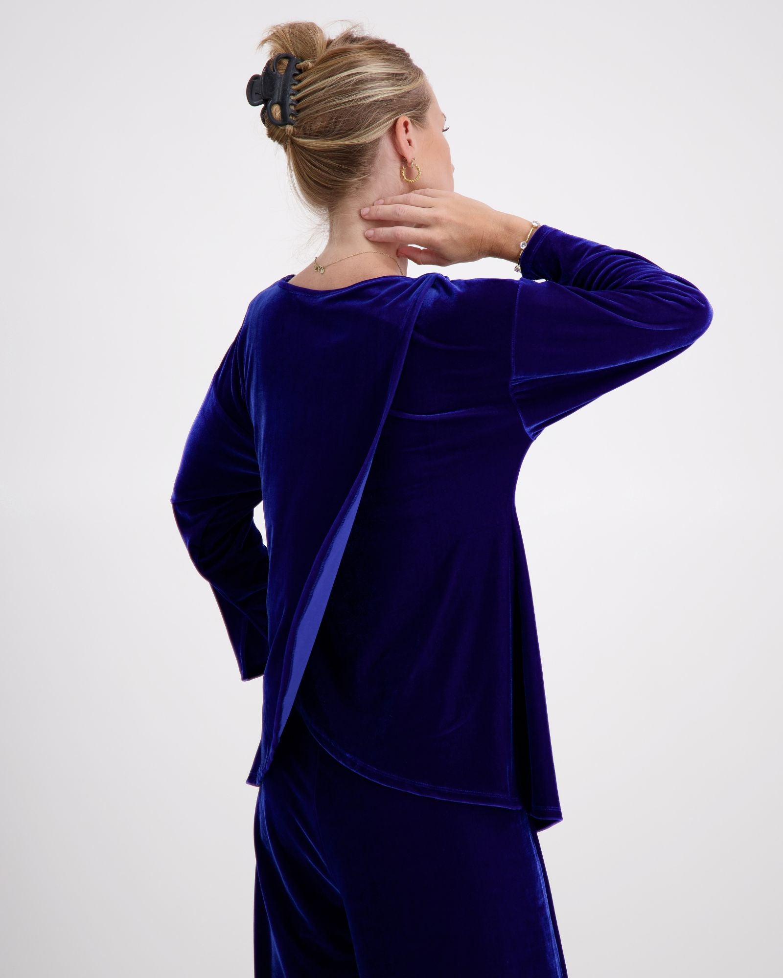 Emma Boat Neck Leaf Back Top shown from behind in luxurious cobalt blue velvet, featuring unique leaf-shaped back design, 3/4 length sleeves with split cuffs, and elegant boat neckline. The plush fabric catches light beautifully, displaying the rich texture of the velvet material.