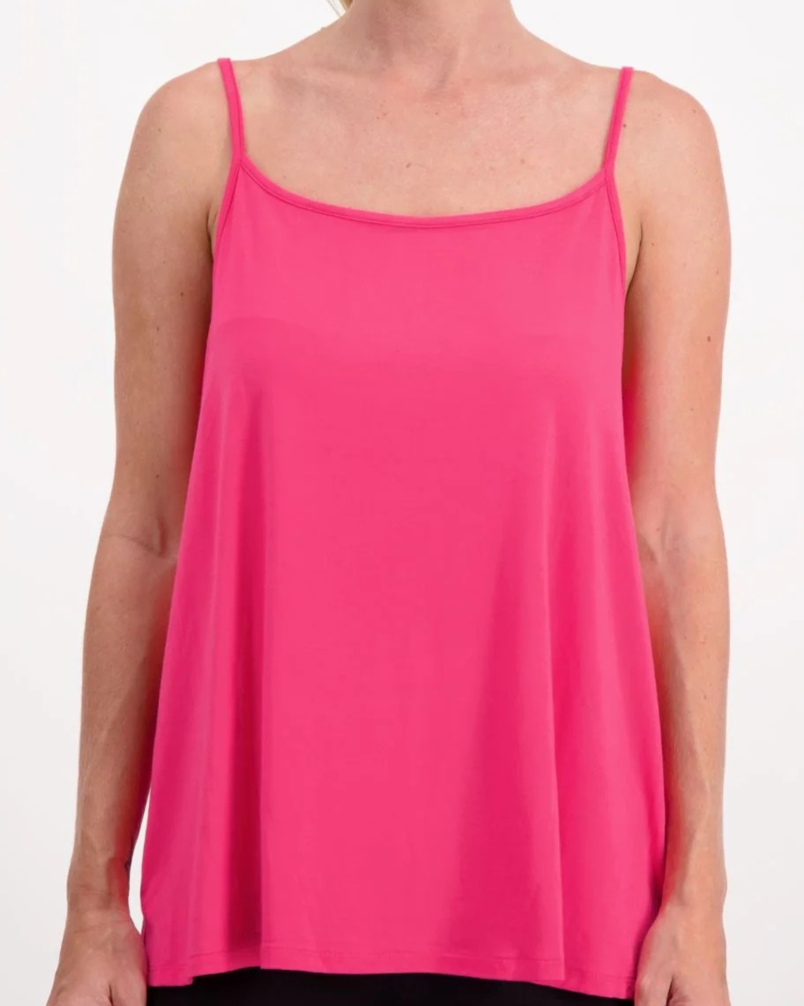 Christine Adaptive Camisole in vibrant pink features a flowy silhouette with delicate spaghetti straps and a scoop neckline. The luxe layering essential showcases a relaxed fit and smooth draping fabric, perfect for versatile styling.