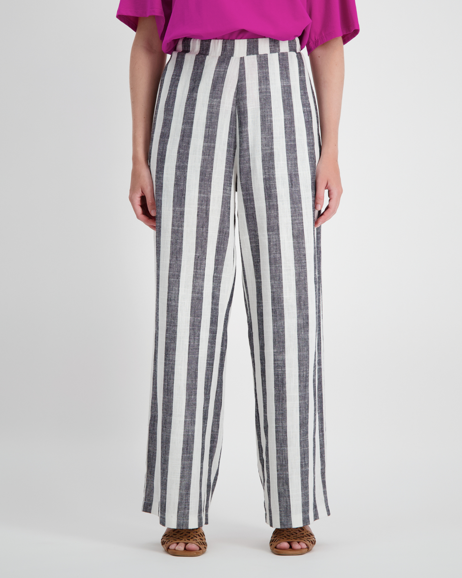 Jessie Wide Leg Pant featuring bold black and white vertical stripes in bamboo and linen blend fabric, styled with a flowing wide-leg silhouette and paired with a vibrant fuchsia top and brown sandals, showcasing adaptive comfort and elegant design