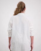 Back view of the Cruiser Magnetic Linen Shirt in crisp white, showcasing the relaxed fit and clean lines of this dexterity-friendly garment against a light gray background. The linen fabric drapes naturally, highlighting the shirt's casual elegance and comfortable design.