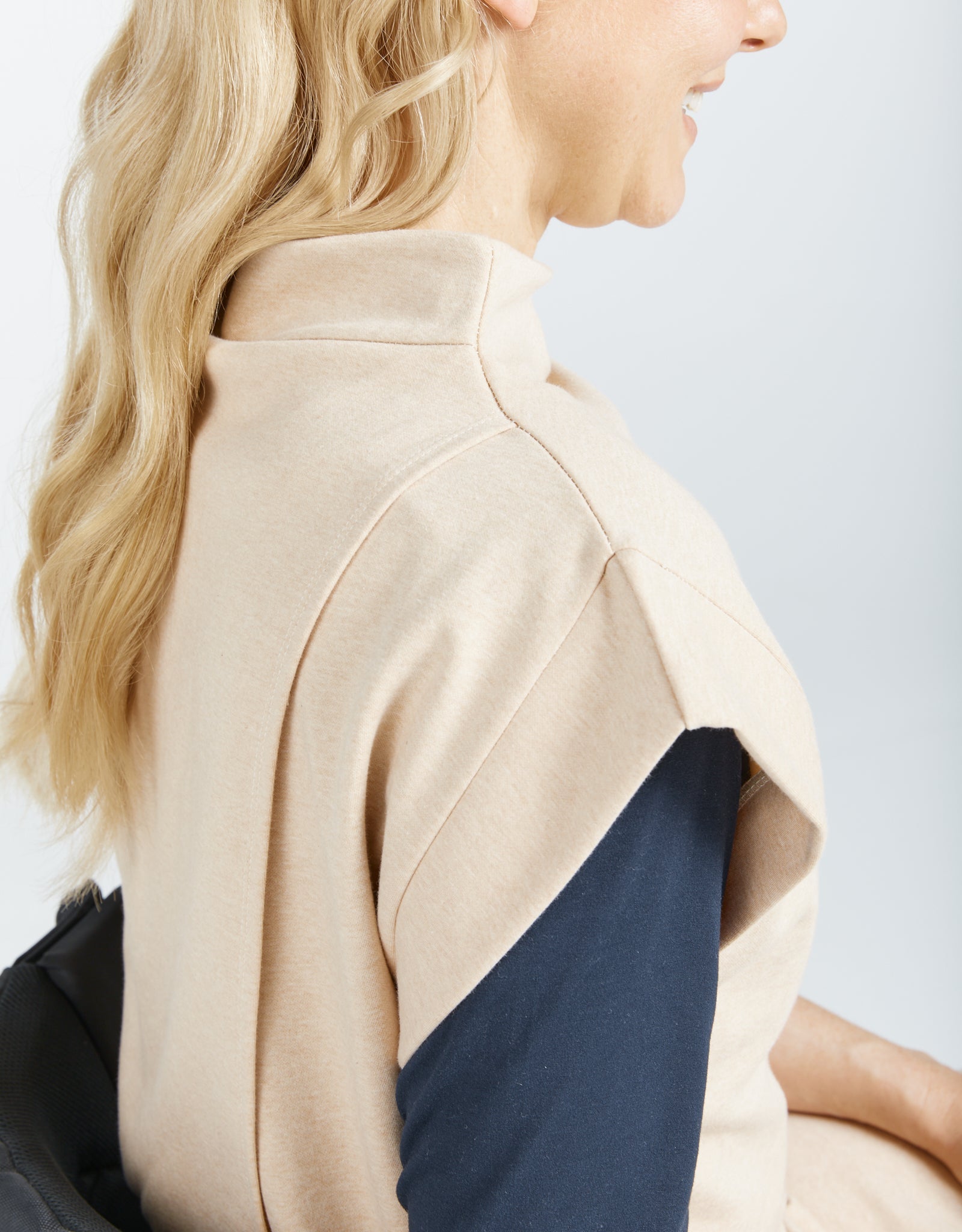 Side profile view of the Leaf Back Dress showcasing the high neckline and unique back design, featuring a natural undyed cotton fabric in beige and navy colorblock pattern with elegant draping details