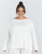 Essensual PJ Top in pure white, featuring a relaxed boat neckline, long sleeves, and flowing fabric design for comfortable nightwear. The loose-fitting top has a curved hemline and casual drape, perfect for peaceful rest and lounging.