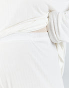 Essensual PJ Pant shown in crisp white fabric with a soft, textured pattern. Close-up detail of the lightweight material with gentle folds and draping, highlighting the comfortable and luxurious sleepwear design.