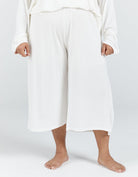 Essensual PJ Pant in pure white, featuring a comfortable wide-leg cropped design with an elastic waistband. Soft, flowing fabric falls to mid-calf length, offering luxurious comfort for nighttime wear. Shown against a light grey background, demonstrating the relaxed, airy silhouette.