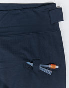 Seated Legging for SP Catheter shown in navy blue with specialized side pocket and reinforced access point for medical devices. Close-up detail of adaptive design featuring secure loops and openings for catheter management in soft bamboo spandex material.