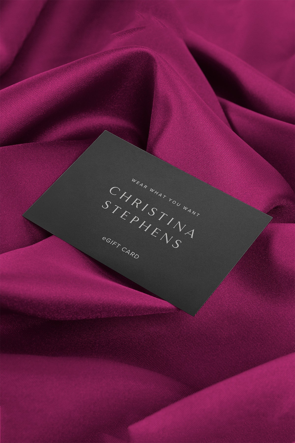 Digital Gift Card displayed on elegant dark gray card against luxurious burgundy silk fabric, featuring minimalist typography and premium presentation for a sophisticated shopping experience