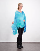 Oceania Kaftan showcasing elegant flowing design in vibrant aqua blue silk with watercolor-like pattern, styled with black leggings and boots against white background, demonstrating versatile formal to casual wear options